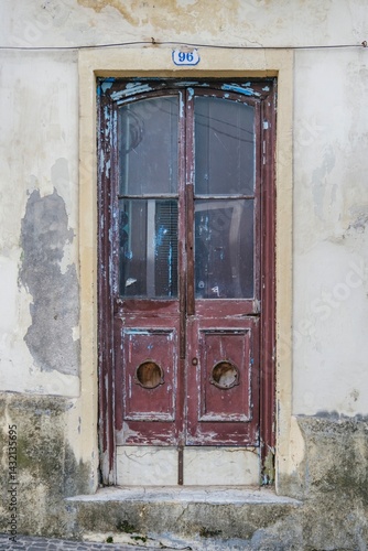 Rustic Charm of a Weathered Doorway: Vintage Architectural Detail in Azores Islands. Old wooden door, distressed paint, weathered texture. Vintage architectural detail showcases a timeworn entrance