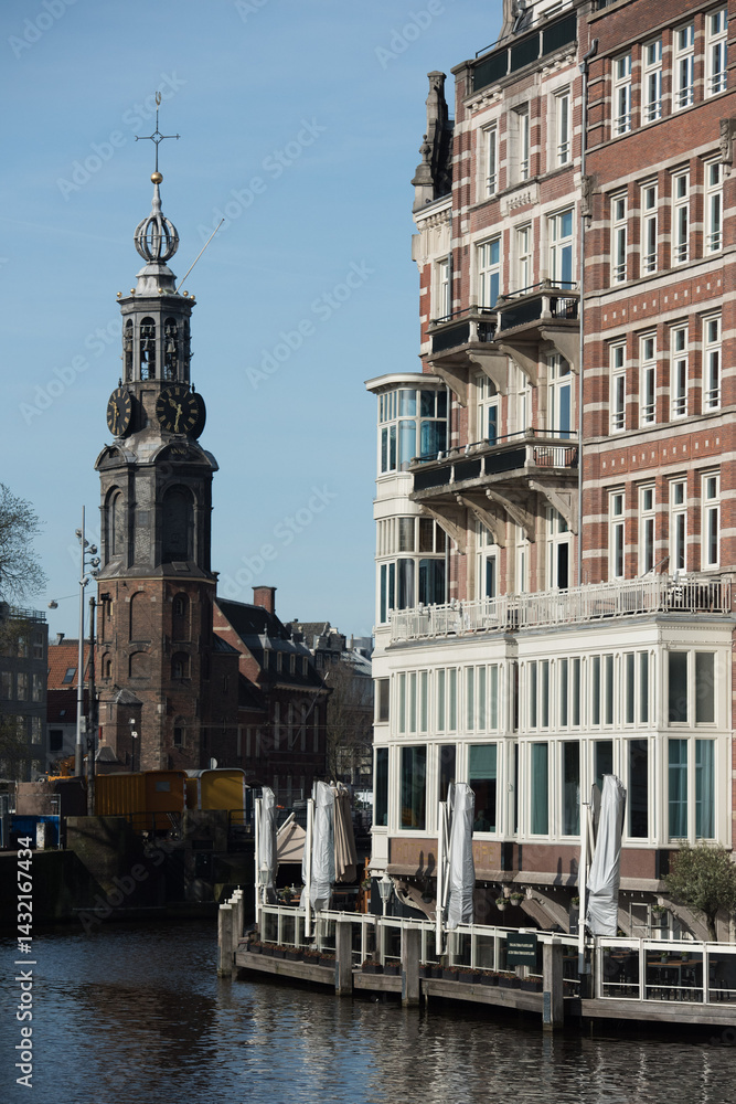 Naklejka premium Canal View with Historical Tower and Riverside Café