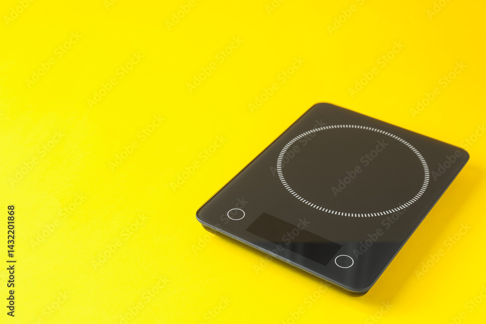 Fototapeta premium Electronic kitchen scale on yellow background. Space for text