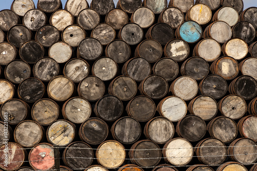 Stacked wooden barrels aged by time, storing fine whisky, wine, or craft beer. Rich textures, warm tones, and artisanal charm captured in close-ups of ancient and noble barriques