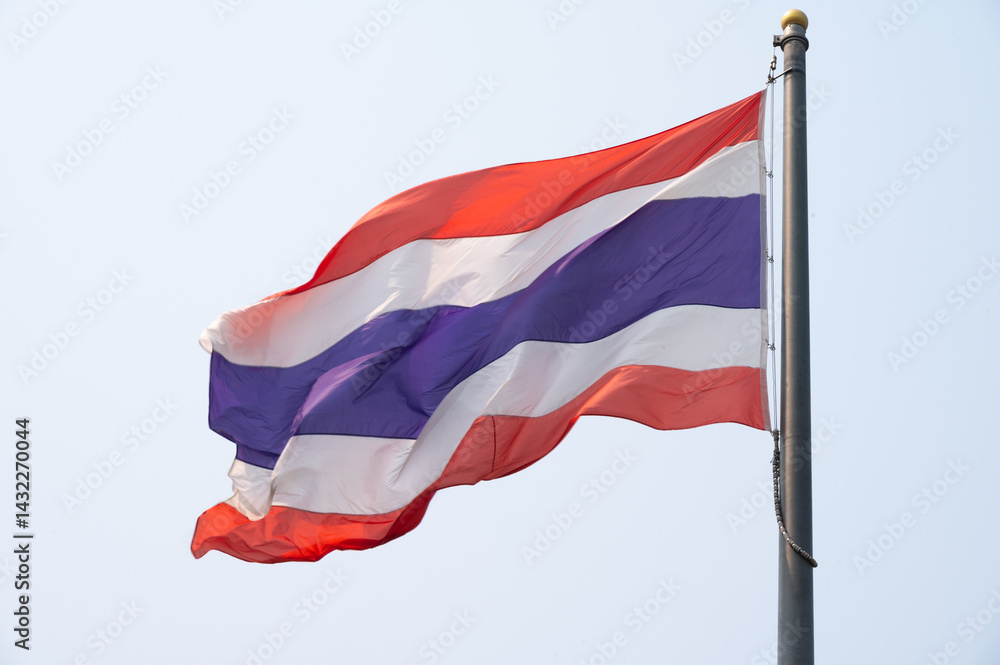 A Thailand national flag blowing by wind against the sky.
