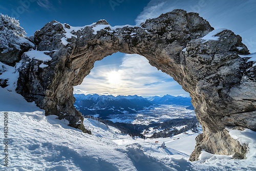 Majestic Stone Arch Framed Winter Mountain Valley Vista with Snow and Bright Sky View