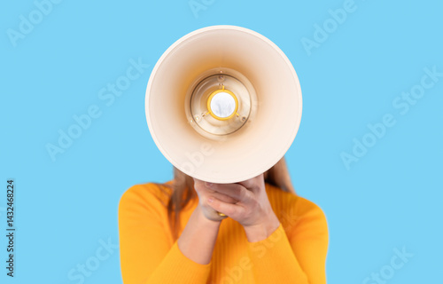 Valokuva Woman holds megaphone in front of her against a bright blue background to amplif