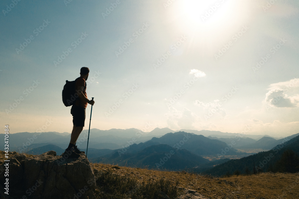 Man climbing to the top of a mountain. Side view of a climber admiring the view of success. Success and adventure.