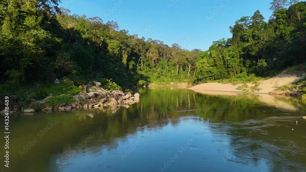 Very low drone shot of the Tembeling River winding through the lush rainforest of Taman Negara, Malaysia. Bright, sunny day, dense tropical foliage, meandering riverbanks, old rainforests. Very low drone shot of the Tembeling River winding through the lush rainforest of Taman Negara, Malaysia. Bright, sunny day, dense tropical foliage, meandering riverbanks, old rainforests.