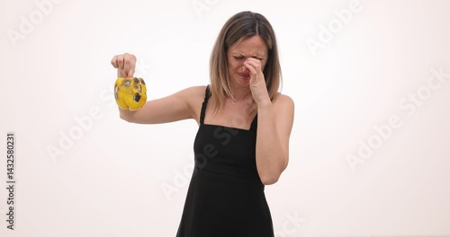 Woman holds moldy bell pepper at arm length with disgusted expression. Wrinkled nose and open mouth demonstrate aversion to decaying vegetable