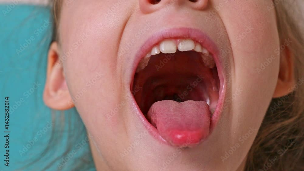 Close-up of little girl opening her mouth wide to the doctor to show