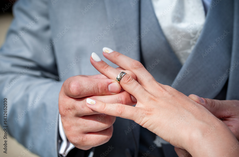 Fototapeta premium Bride and Groom Exchanging Wedding Rings During Ceremony in Close-Up View