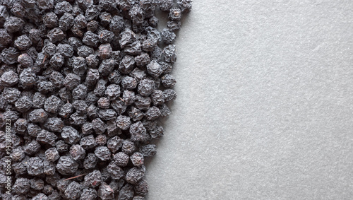 Obraz na płótnie Close up photo of organic dried aronia berries on a dark slate background, selective focus. w salonie