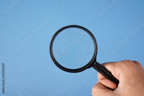 Hand holding magnifying glass
