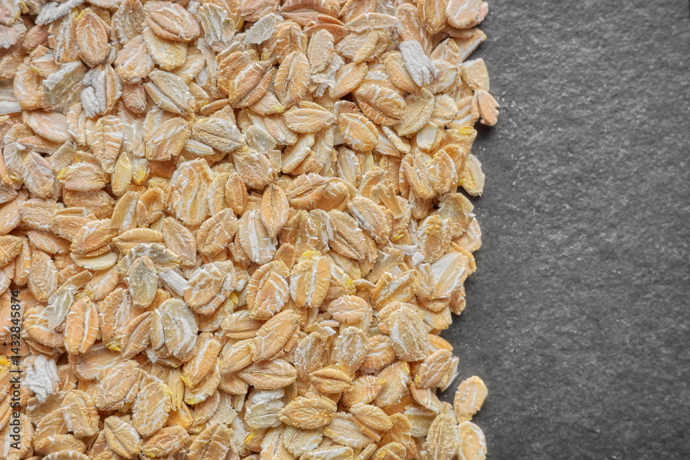 Close up photo of organic rye flakes on a dark slate background, selective focus.