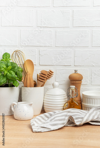 Obraz na płótnie Kitchen utensils, basil plant and linen napkin creating cozy atmosphere on table w salonie