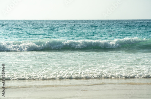 Obraz na płótnie Clear turquoise waves gently crashing on a peaceful sandy beach at a tropical island coastline w salonie