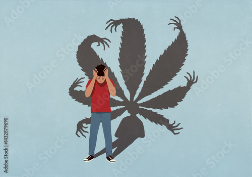 Cannabis leaf shadow with hands looming behind overwhelmed young man with head in hands
 photo