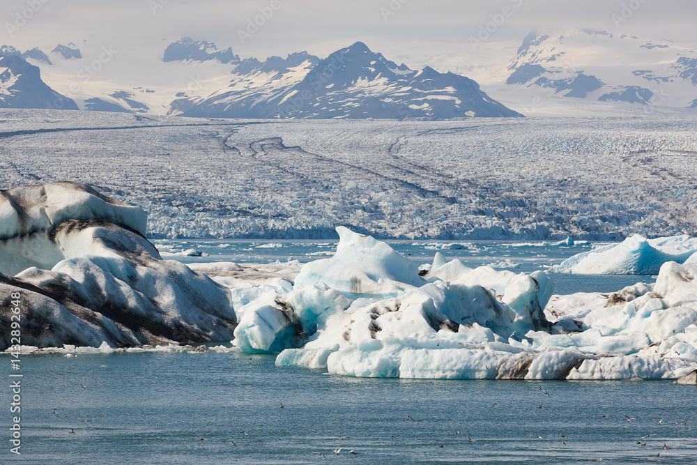 Icebergs turquoise lake and snowy mountains. Jokulsarlon, Southeast area. Iceland.
