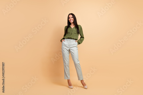 Obraz na płótnie Confident businesswoman posing with elegance in formal attire, showcasing professional style and sophistication against a beige background w salonie
