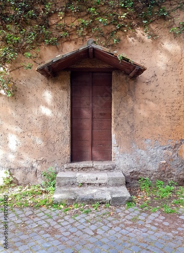 Obraz na płótnie Old wooden door in the wall of an old house. Italy. w salonie