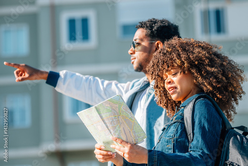 young latin couple traveling with a map in summer outdoors