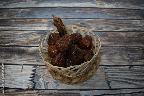 A simple yet aesthetic arrangement of kelubi fruit in a handmade bamboo basket.