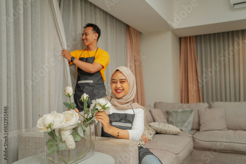A cheerful and happy couple is enjoying their home decor in the stylish and cozy living room
