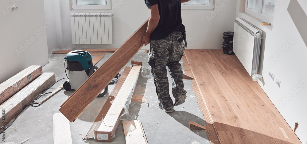 Professional handyman installing laminate flooring in a new apartment.