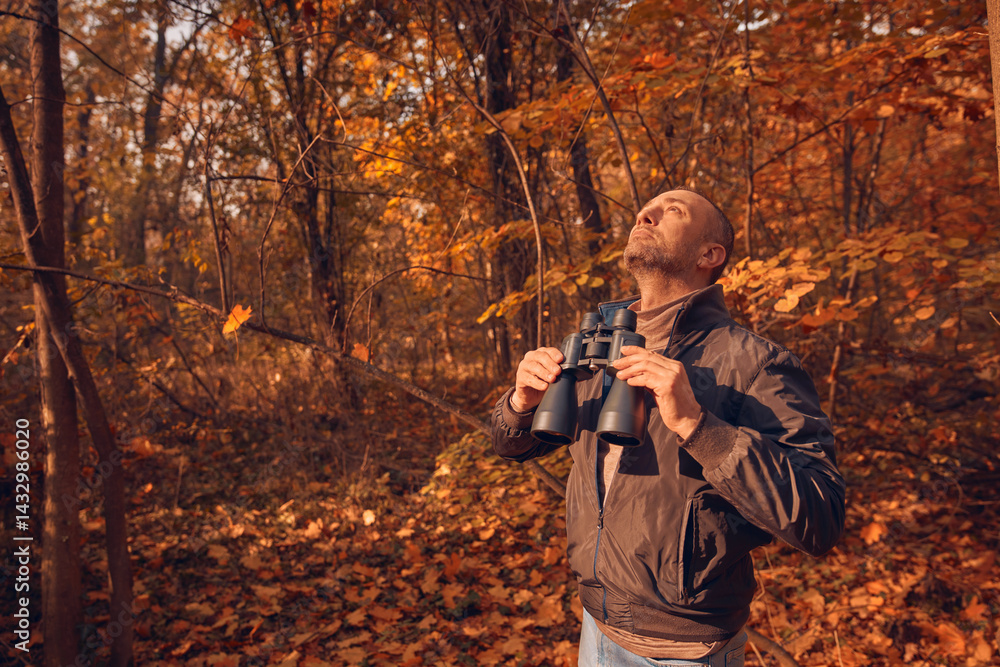 Amateur birdwatcher observing birds and other animals in nature with binoculars.