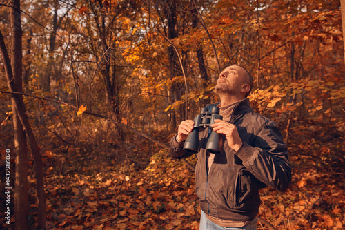 Obraz na płótnie Amateur birdwatcher observing birds and other animals in nature with binoculars. w salonie