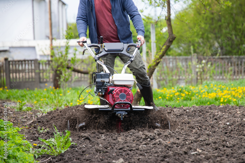 Farmer using tiller on a plowed field Farmer using tiller on a plowed field