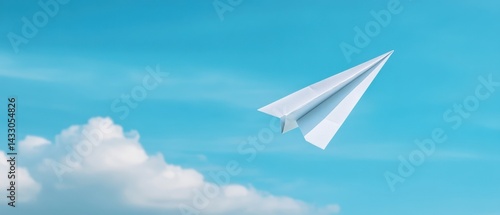 Paper airplane soars in blue sky