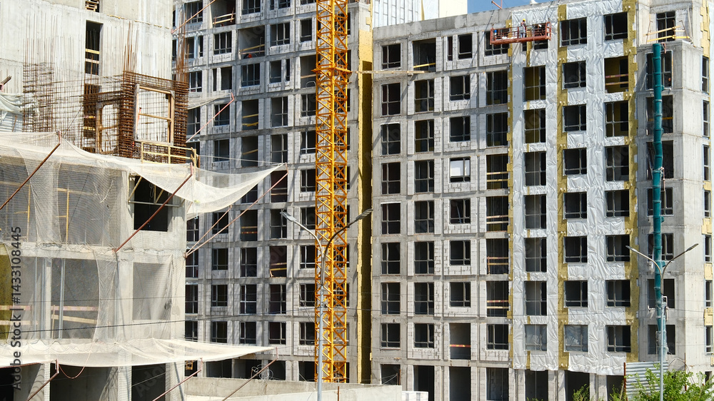 Fototapeta premium construction site under development with cranes and safety nets