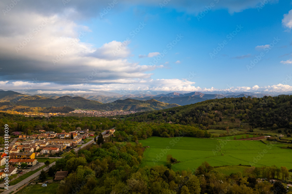 Naklejka premium spectacular aerial view of Garrotxa region in Catalonia, Spain, at sunset with cloudy sky. Scenic view of natural landscape nearby Olot