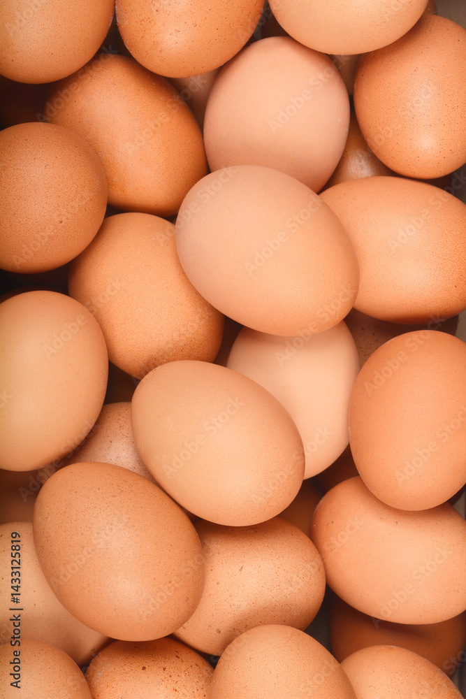 A tightly cropped, top-down shot shows many brown chicken eggs filling the frame