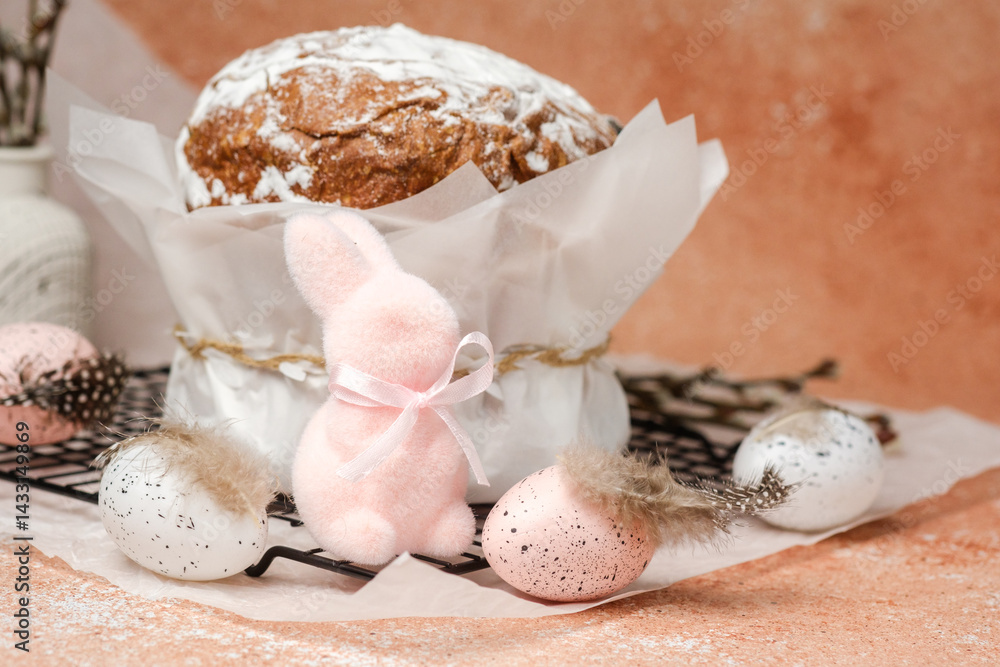 Easter celebration composition with traditional cake, pastel speckled eggs and decorative pink bunny. Spring holiday scene...