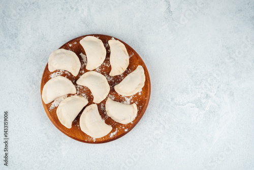 Obraz na płótnie Delicious handmade dumplings arranged on wooden plate in kitchen w salonie
