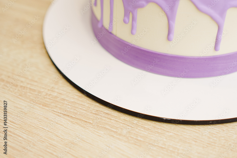 A fragment of a cake decorated with streaks of purple icing.