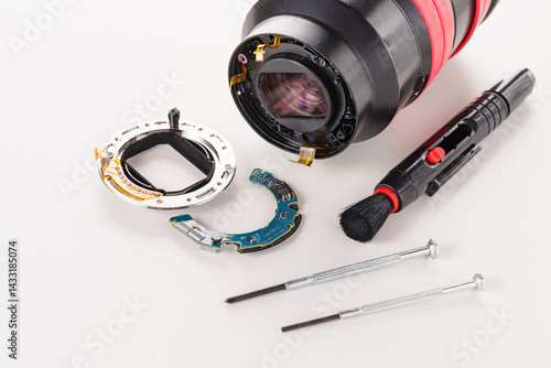 Obraz na płótnie A broken lens of a professional camera and repair tools on a white table. w salonie