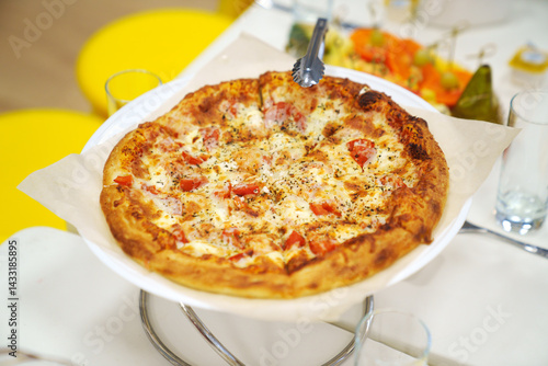 Obraz na płótnie close-up. A large margherita pizza on the table with appetizers for the holiday. w salonie