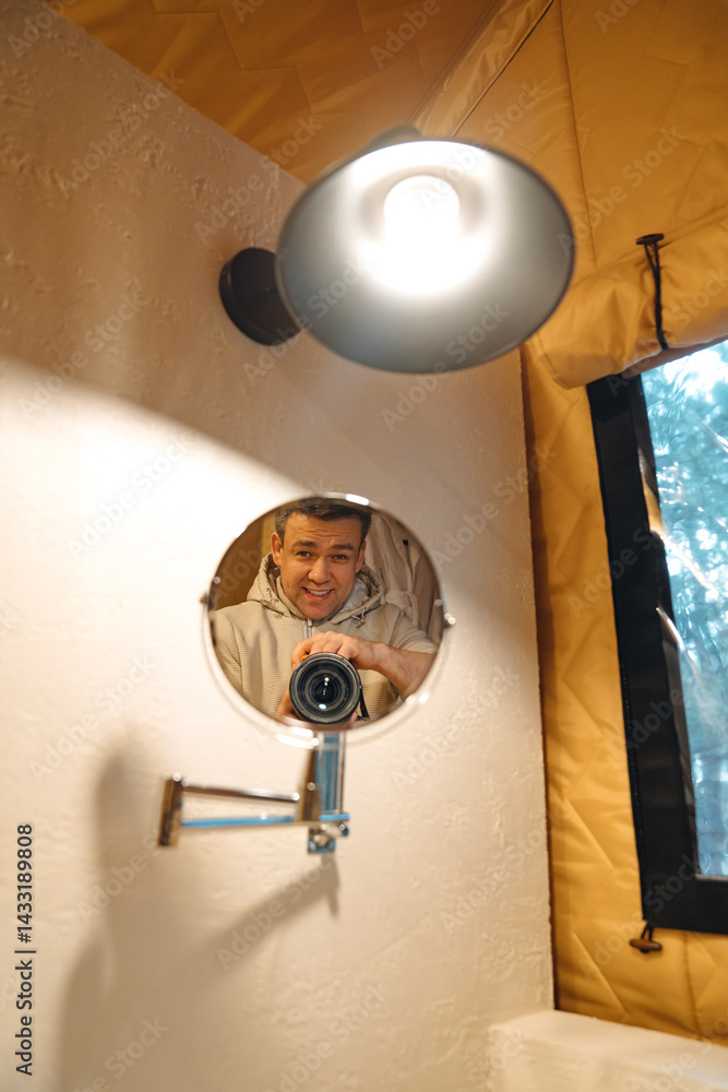 Lamp and round mirror in the bathroom in the tent house in the glamping.