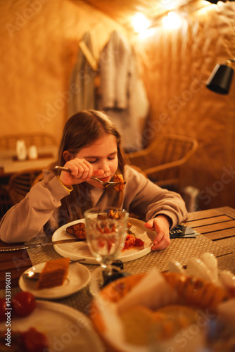 Obraz na płótnie Selective focus. Teenage girl eating in the semi-darkness in a cafe. w salonie