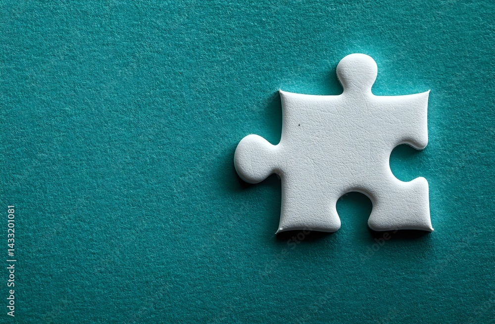 Obraz premium Single white jigsaw puzzle piece casting soft shadow on turquoise textured background, symbolizing solution, connection and business strategy concepts.