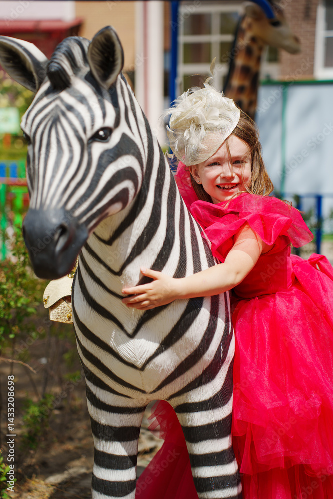 A girl in an lush pink dress is playing on the playground with animal sculptures