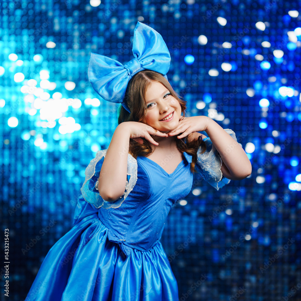 Cute teenage girl in blue doll dress with big blue bow posing.