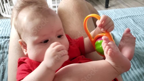 A Four-Month-Old Girl Plays On Daddy's Lap