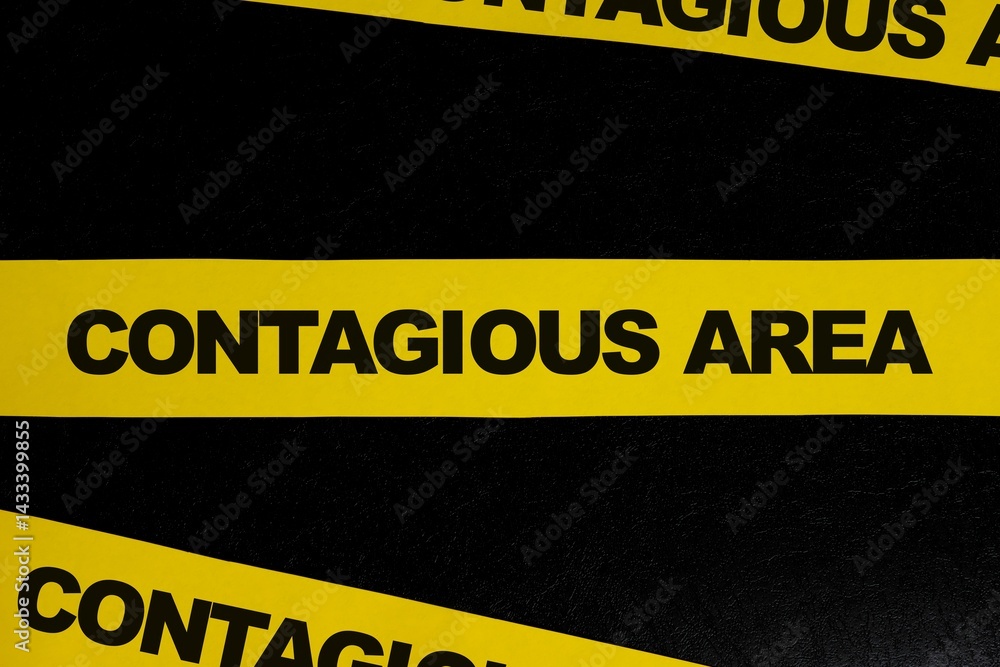 Contagious area and infectious disease caution, danger and warning concept. Yellow barricade tape with word in dark black background.