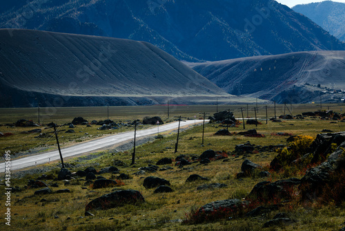 A road cutting through the rugged and dramatic landscape of the Altai Mountains in the Altai Republic, surrounded by raw nature and vast open spaces.