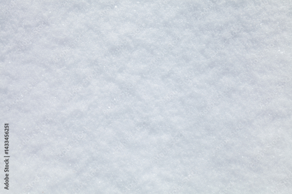 Fototapeta premium The ground is covered in a thick layer of white snow, which is powdery and soft to the touch. The snow is spread evenly across the entire surface, creating a serene and peaceful atmosphere
