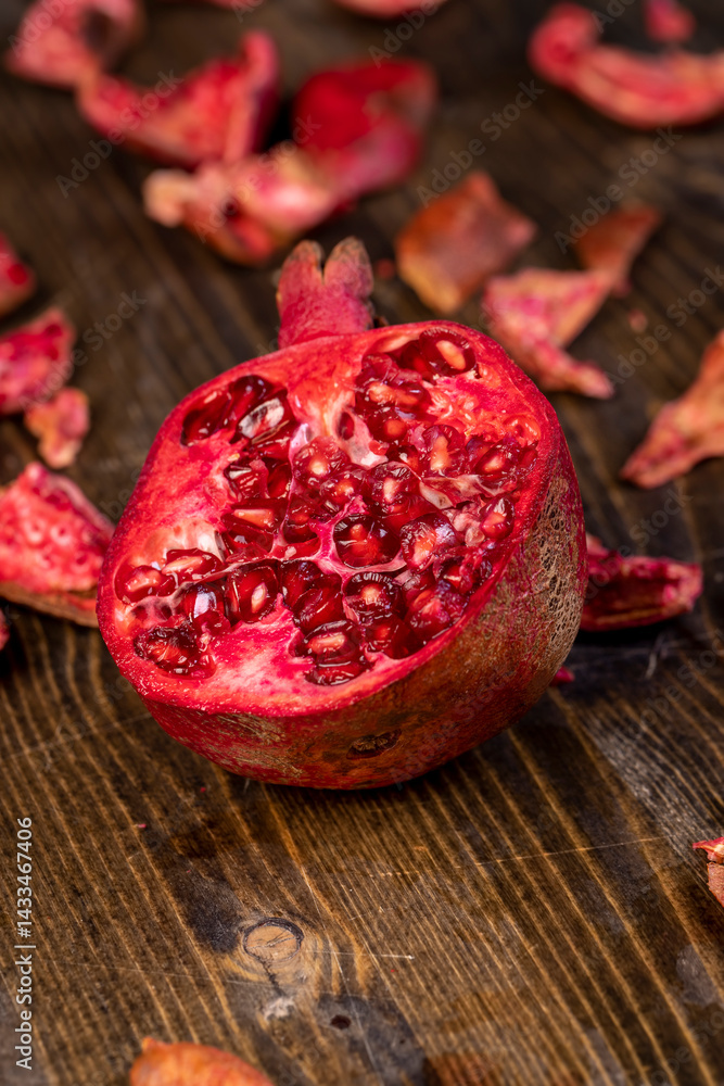 sliced red pomegranate on a table, sweet red pomegranate cut into pieces during cooking, close up