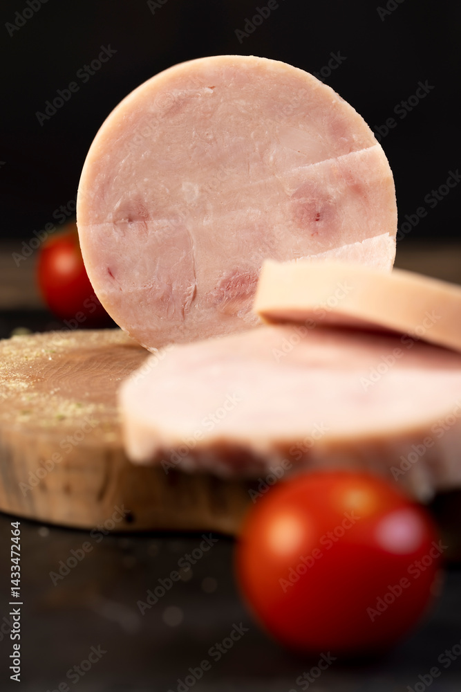 chicken ham from different pieces of meat during slicing and ripe red tomatoes
