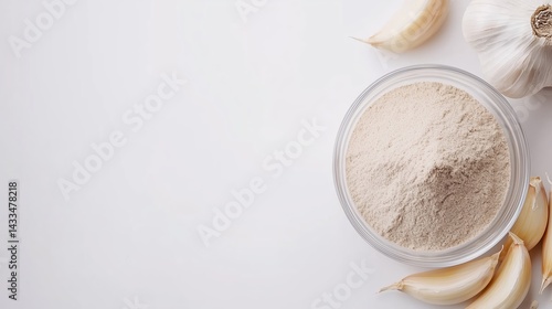 Garlic Powder in Bowl with Fresh Garlic Cloves on White Background