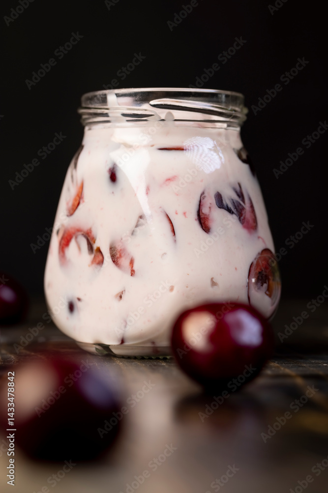 fresh cow yogurt with cherry flavor and berry , jar with cherry yogurt with fresh red cherries